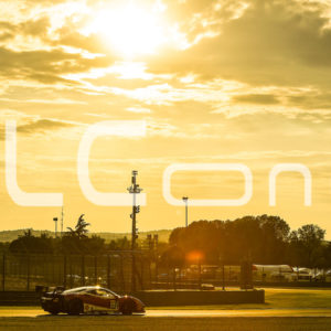 photo of a racing car under a sunset