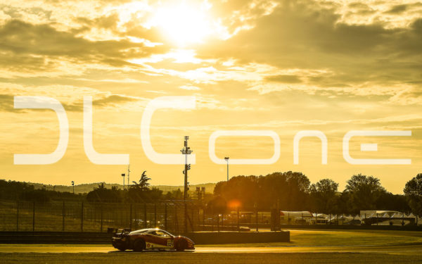 photo of a racing car under a sunset